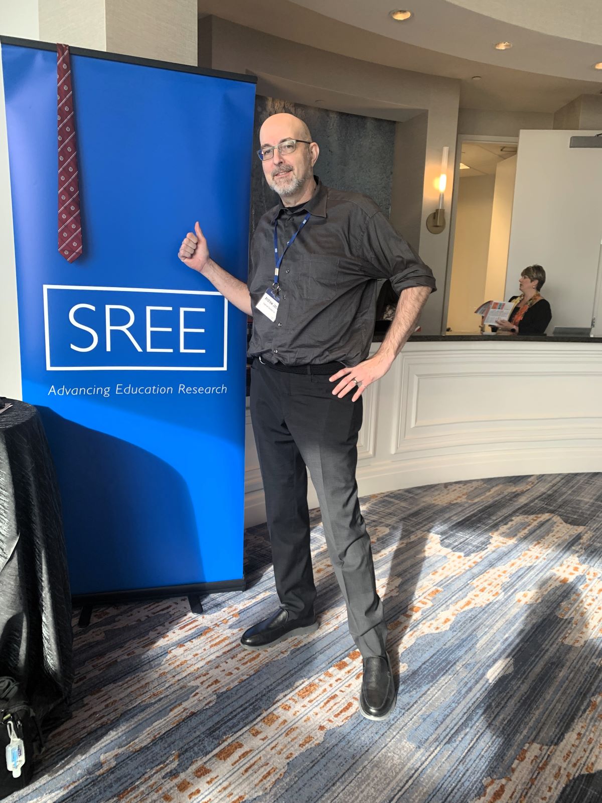 Andrew standing by the sree banner